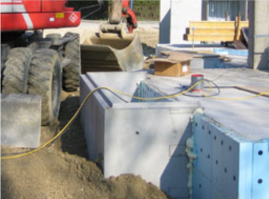 Betonlichtschacht auf Baustelle mit Bagger
