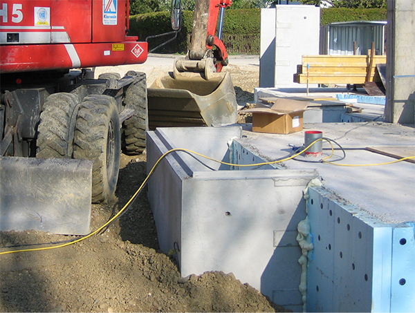 Betonlichtschacht auf Baustelle mit Bagger